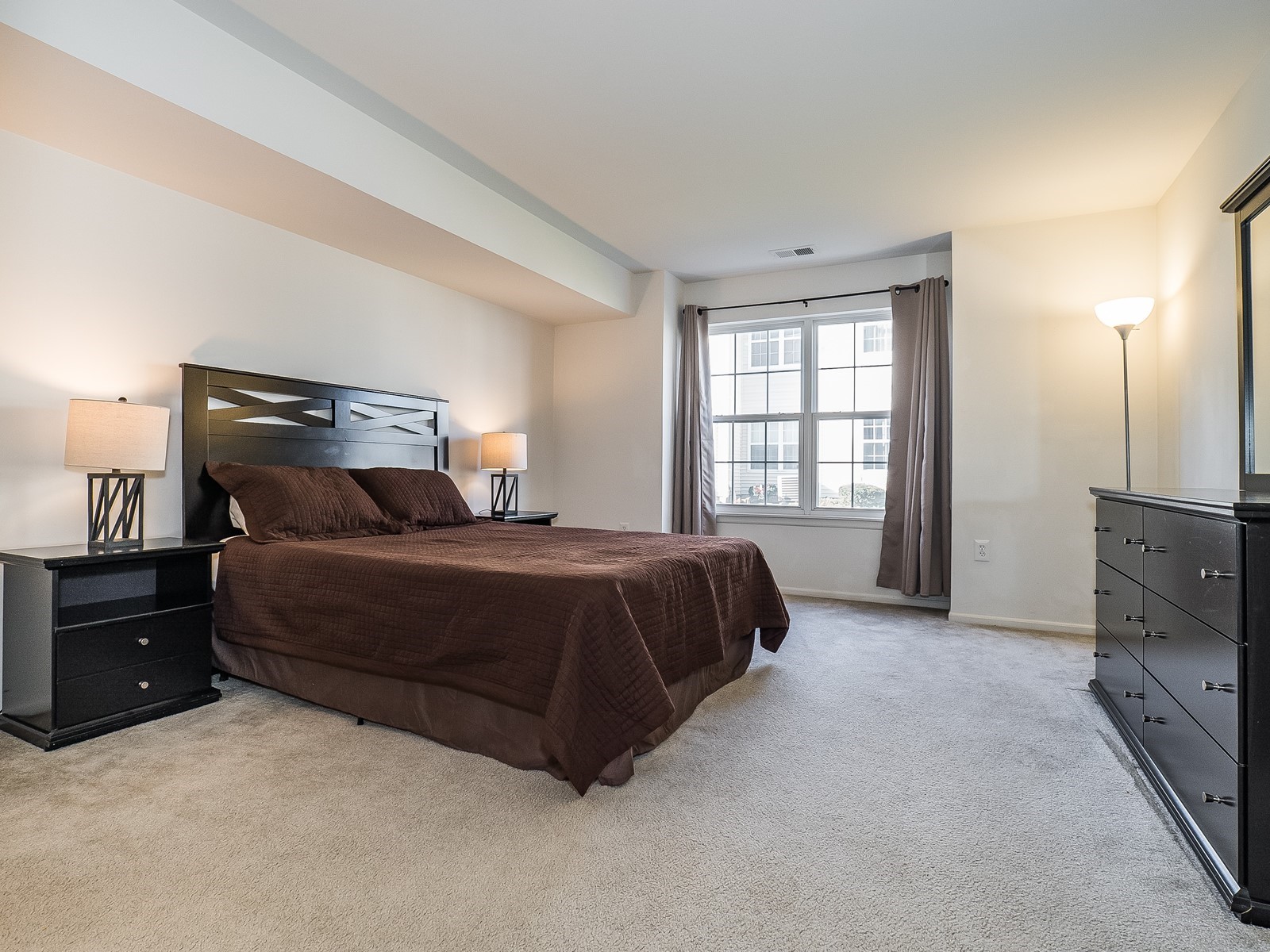 Woodbridge 801 Short Term Housing Master bedroom with large bed, dresser and nightstands